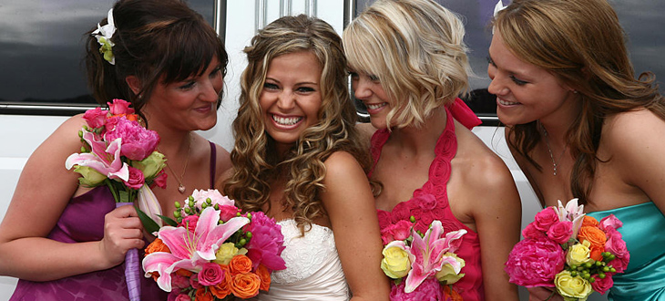 Happy bride and her bridesmaids in front of Chicago Cadillac limousine