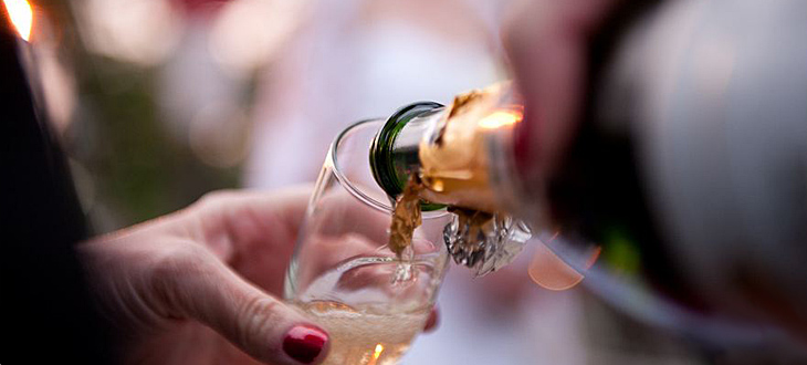 champagne being poured into a flute next to the limousine